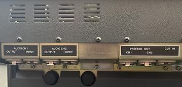 Close-up of a panel with audio input and output ports, labeled 