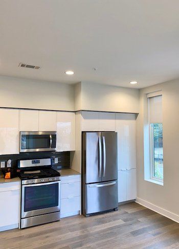 A kitchen with stainless steel appliances and white cabinets.