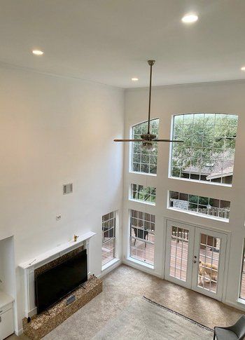 A living room with a fireplace and a ceiling fan.