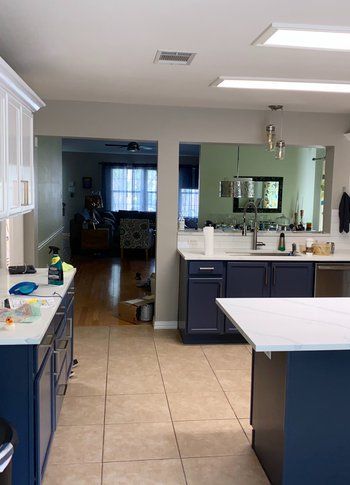 A kitchen with blue cabinets and white counter tops