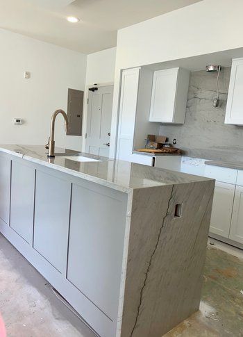 A kitchen with a large island and a sink.