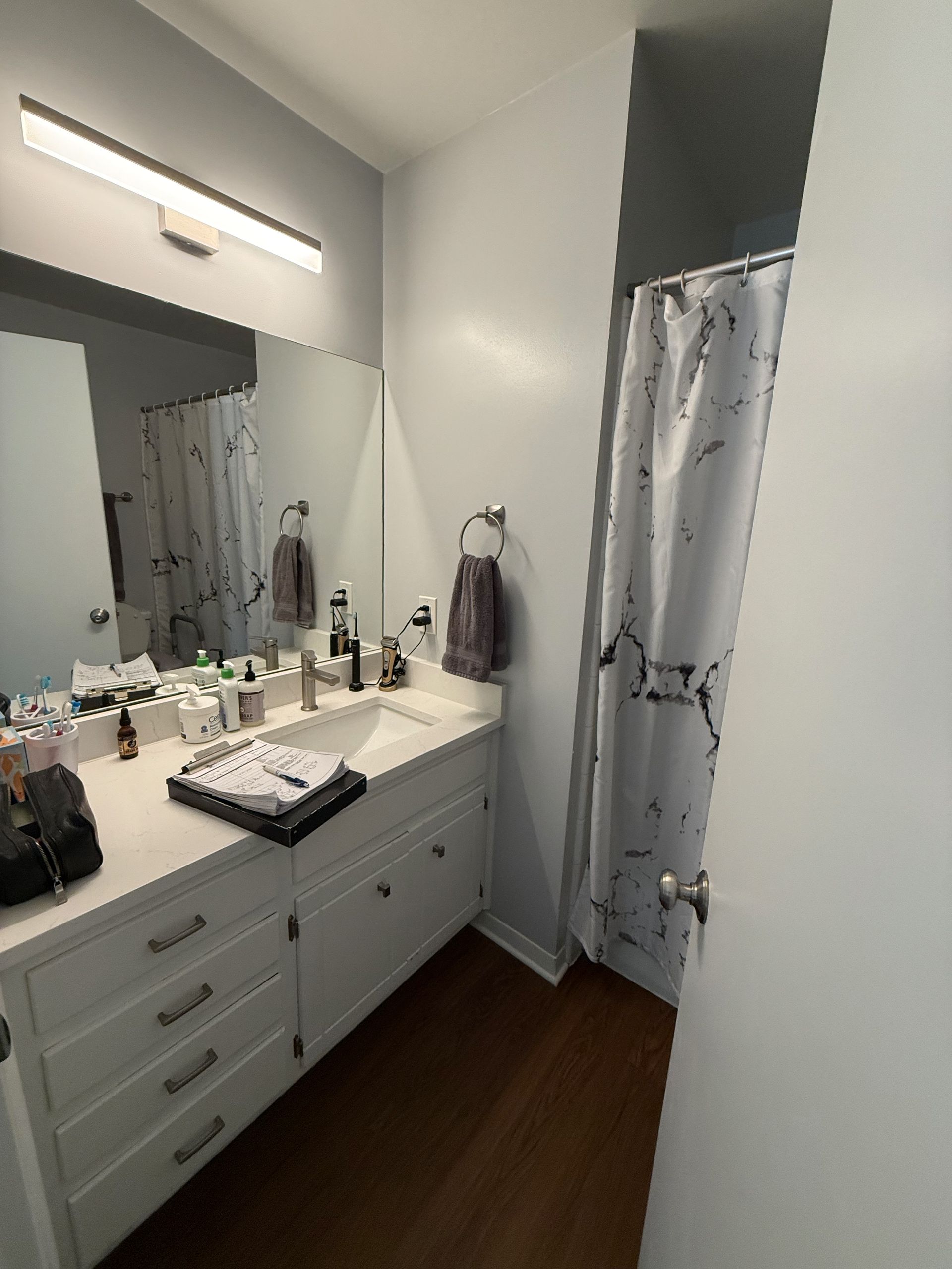Bathroom cabinets before refacing in Austin with outdated laundry chute drawer