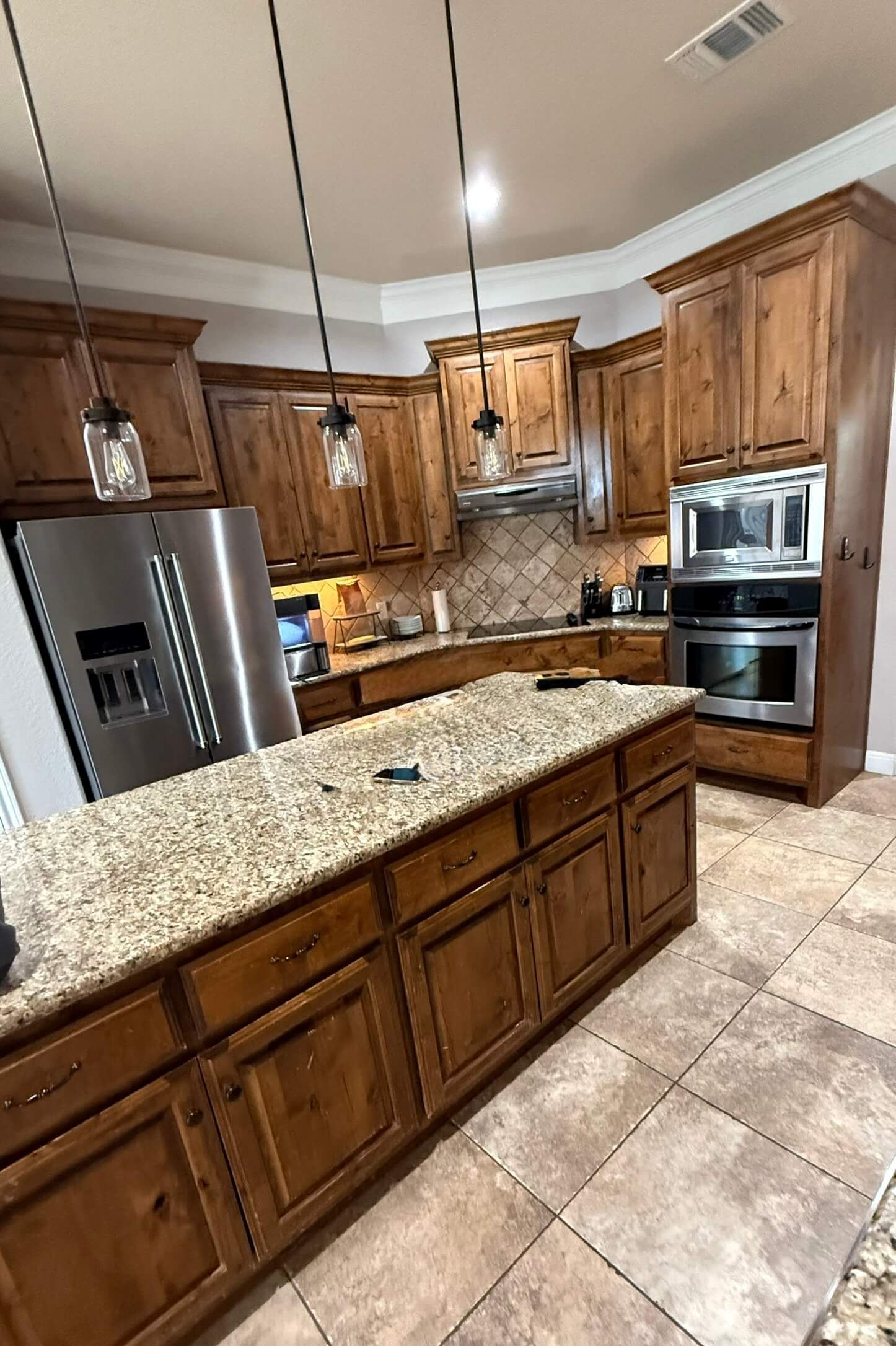 Before Liberty Hill kitchen remodel with dark stained cabinets, older countertops, and original finishes