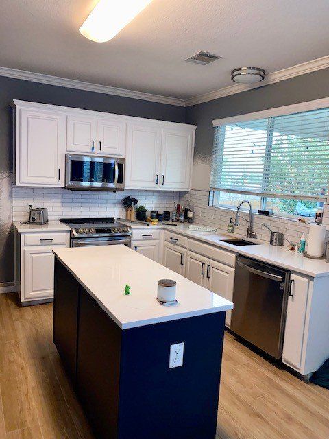 Home in Round Rock, TX with full kitchen remodel including cabinet painting, new countertops, and new backsplash completed by Austin Painting and Cabinets