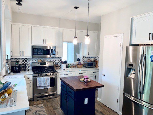 A kitchen with stainless steel appliances and white cabinets