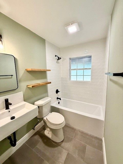 East Austin bathroom remodel with new tub, fixtures, floating shelves, and modern finishes