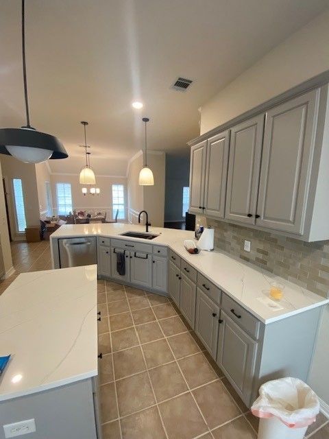 Home in Austin, TX with full kitchen remodel including cabinet painting, new countertops, and new backsplash completed by Austin Painting and Cabinets