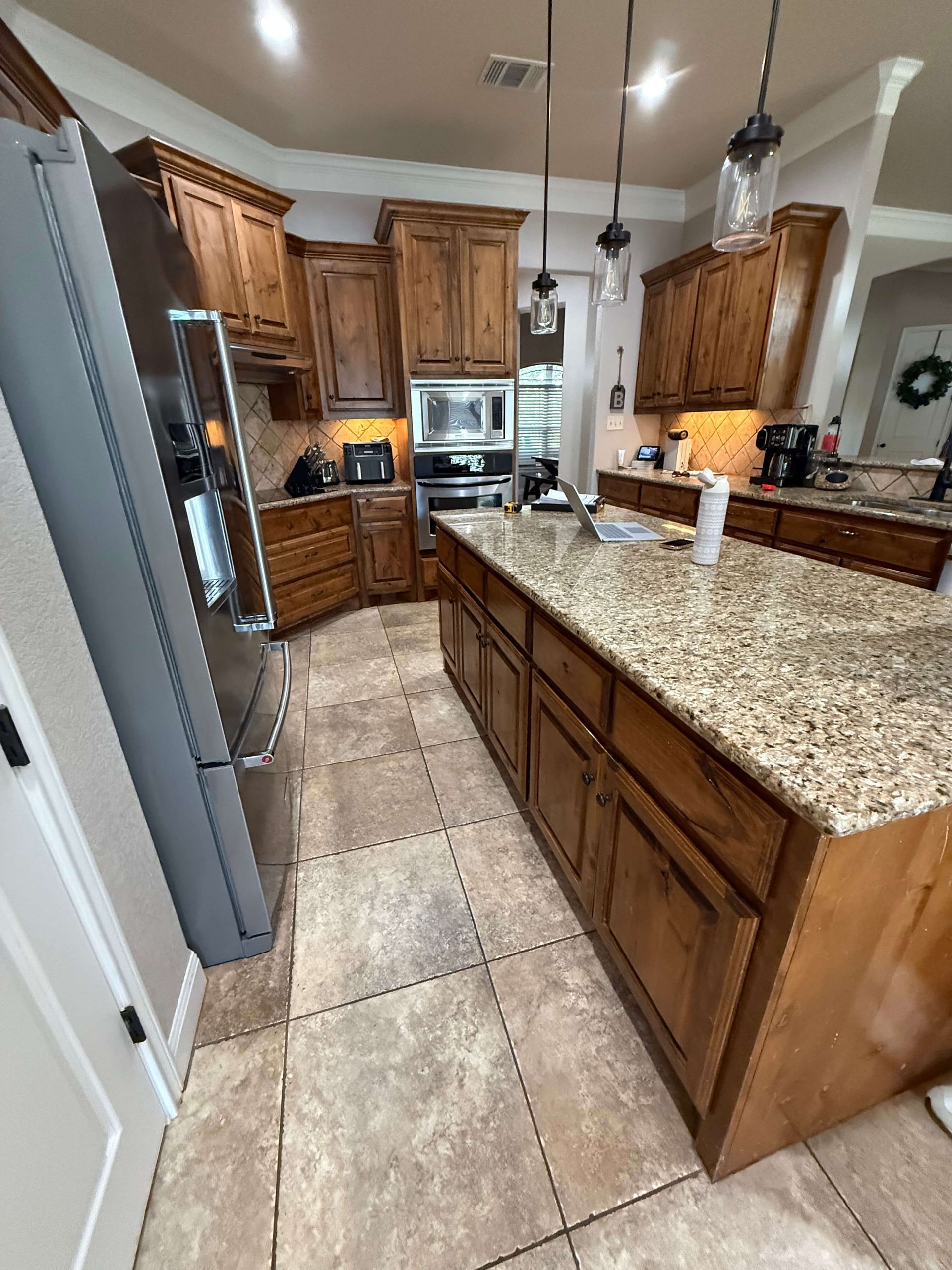 Second before photo of Liberty Hill kitchen remodel showing original island, stained cabinetry, and existing surfaces