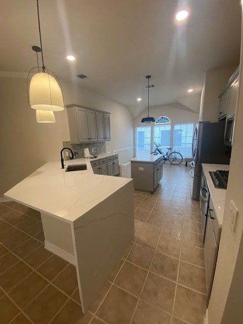 Home in Austin, TX with full kitchen remodel including cabinet painting, new countertops, and new backsplash completed by Austin Painting and Cabinets