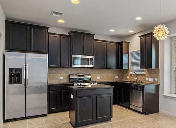Before North Austin kitchen remodel with darker cabinets and dated finishes