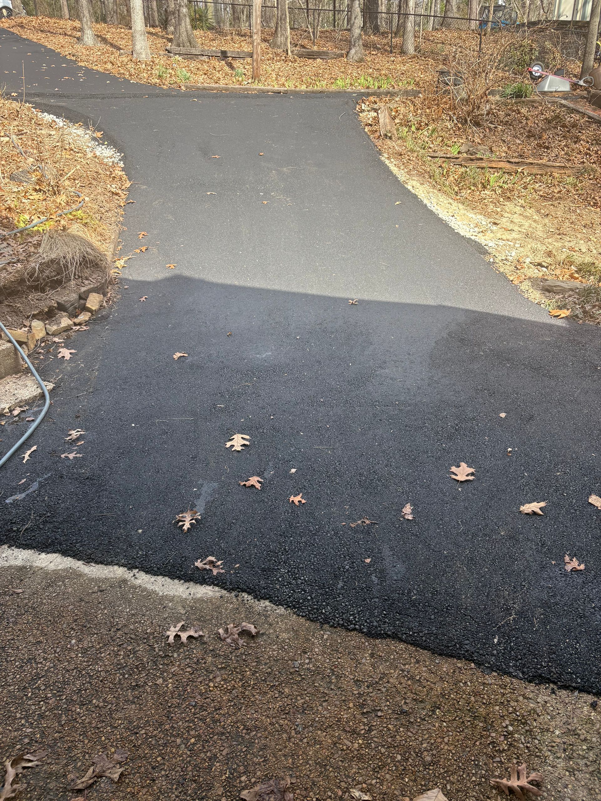 Newly paved asphalt driveway turns into an existing asphalt road.