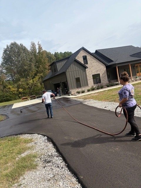 Yellow steamroller compacting asphalt on a road.