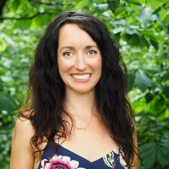 a woman in a blue floral dress is smiling for the camera .