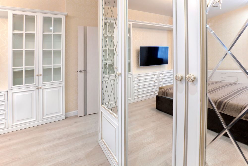 A Bedroom With A Bed, Television And Mirrored Doors — Nobbs & Myers Glass In Brunswick Heads, NSW