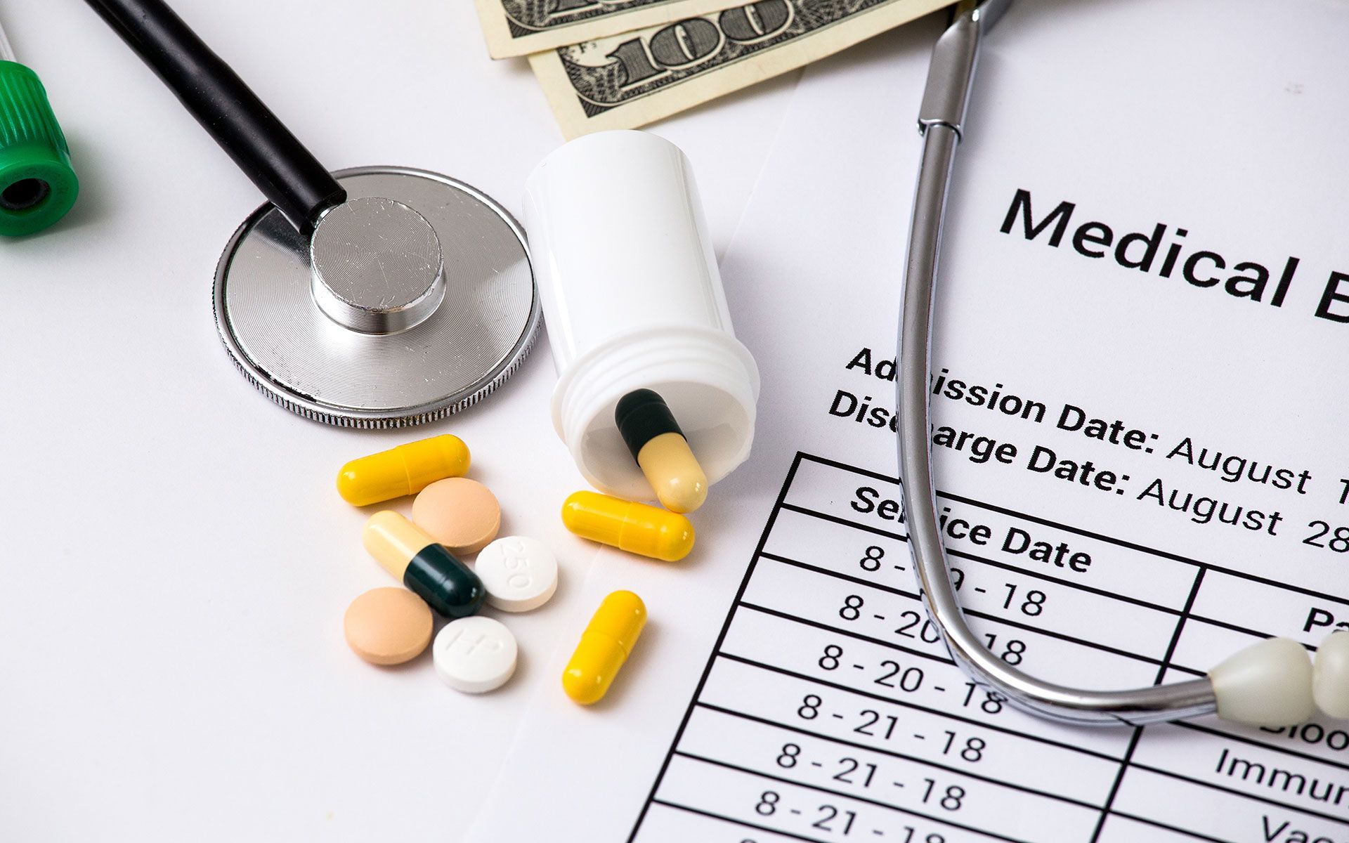 Medical bill with stethoscope, pills, and cash, symbolizing healthcare costs.