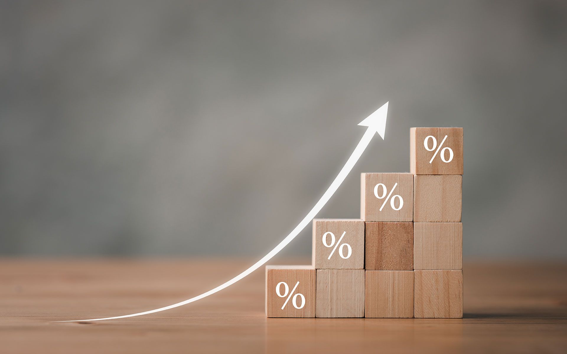Wooden blocks stacked like steps, with a white arrow pointing upward, showing percentage signs.
