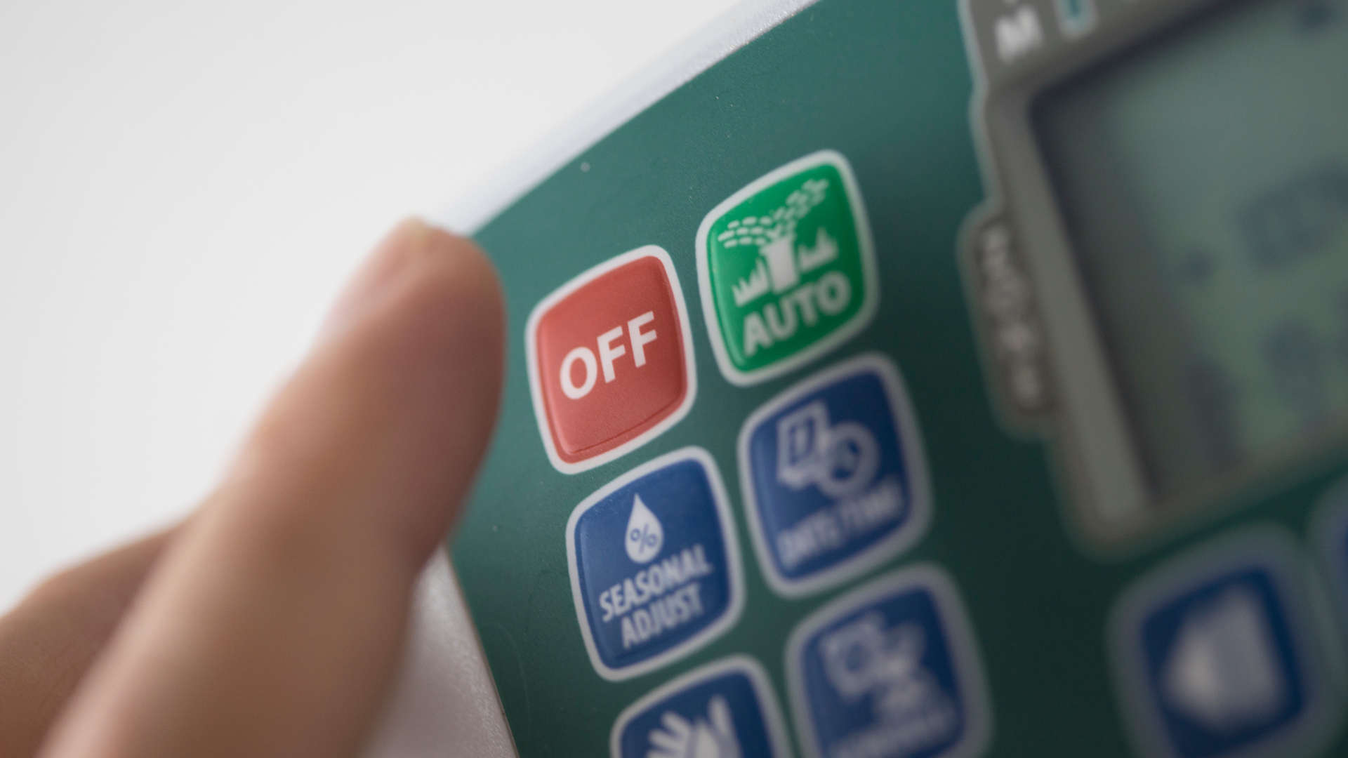 A person is pressing the off button on a remote control.