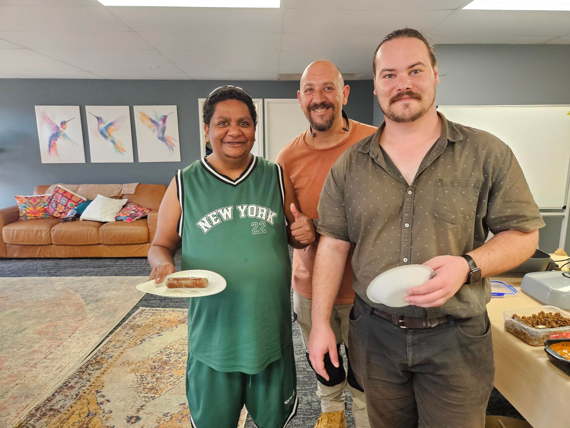 Three People Pose For A Photo In An Indoor Setting, With The Person On The Left Holding A Plate — Advanced Therapy Mackay In Mackay, QLD 