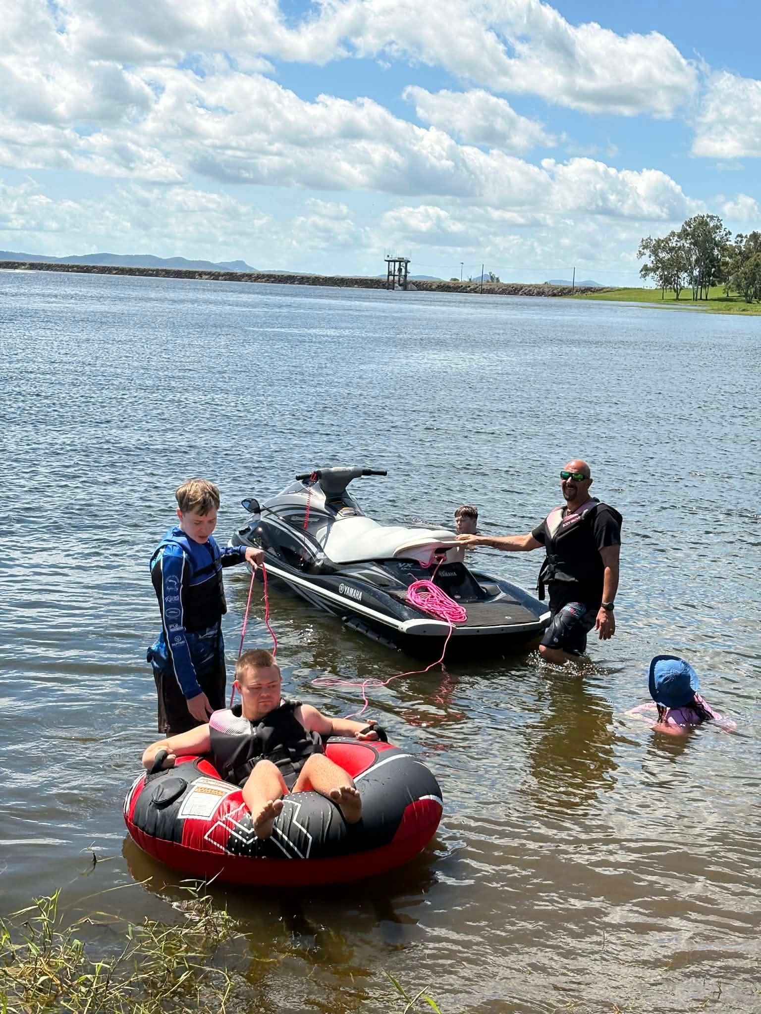 A Woman Is Teaching A Young Girl How To Use A Tablet Computer — Advanced Therapy Mackay In Mackay, QLD 