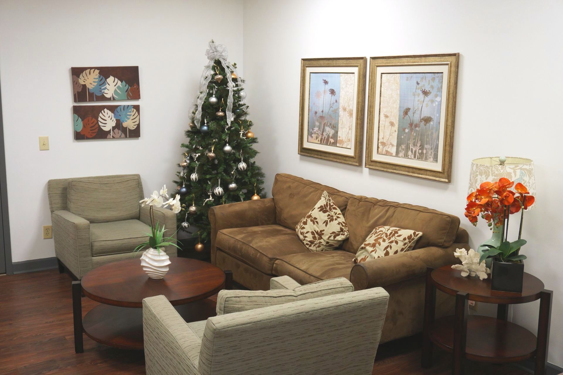 A living room with a couch , chairs and a christmas tree