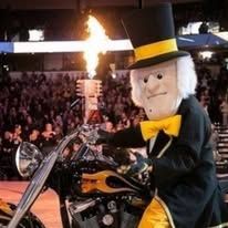 Mascot in top hat and yellow bow tie on a motorcycle with flames behind.
