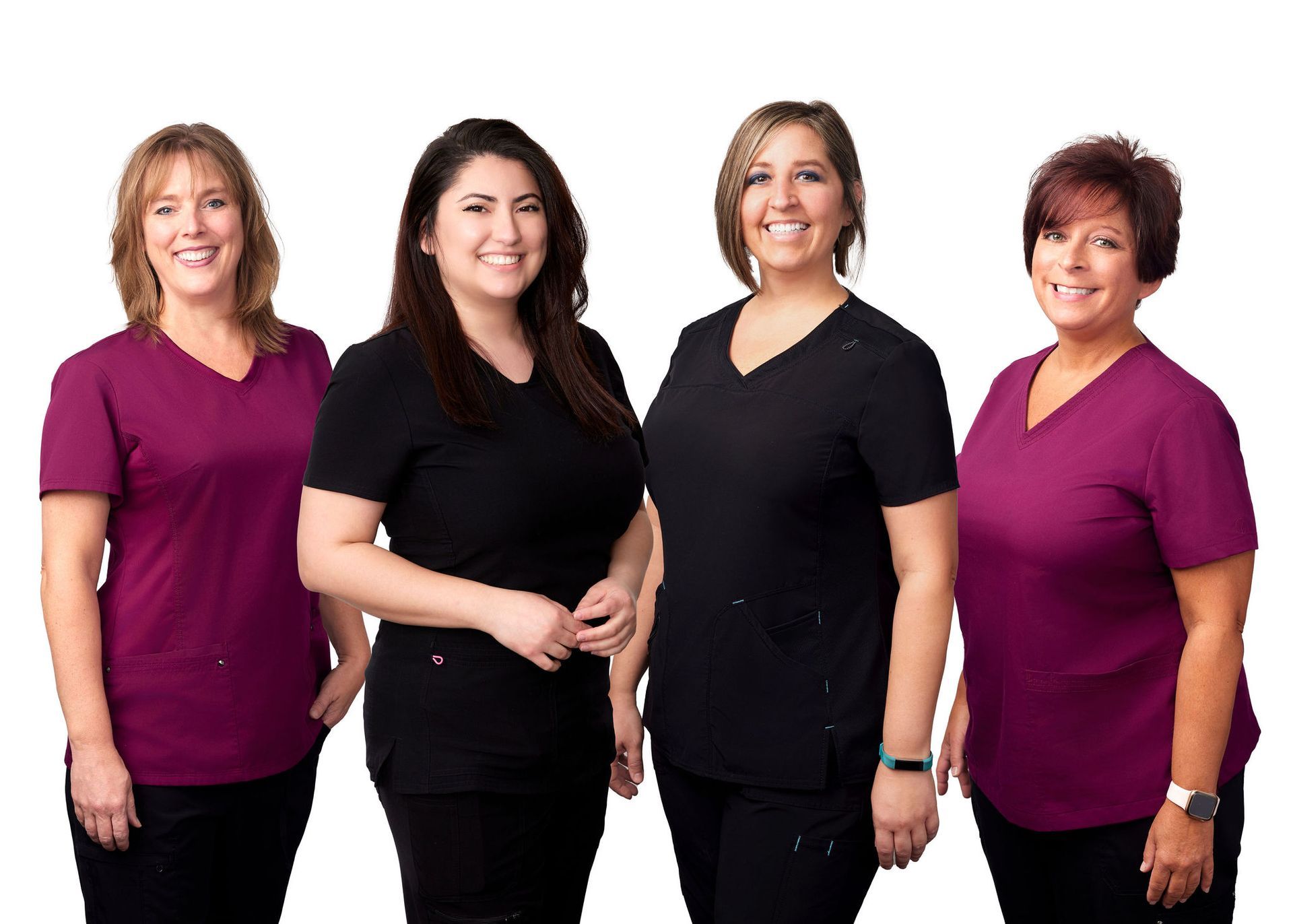 A group of four women in scrubs are posing for a picture.