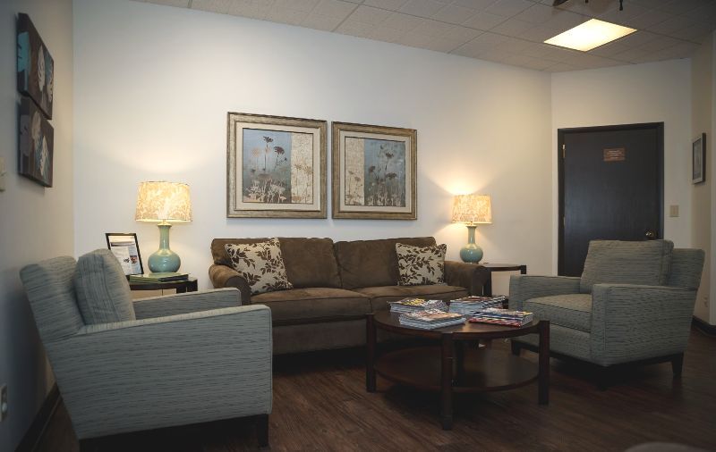 A living room with a couch and two chairs