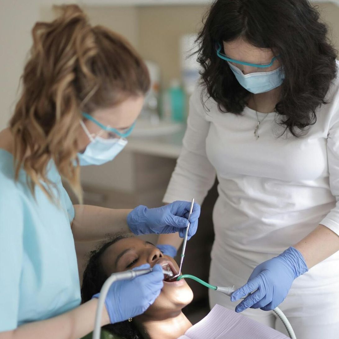 A woman is getting her teeth examined by a dentist