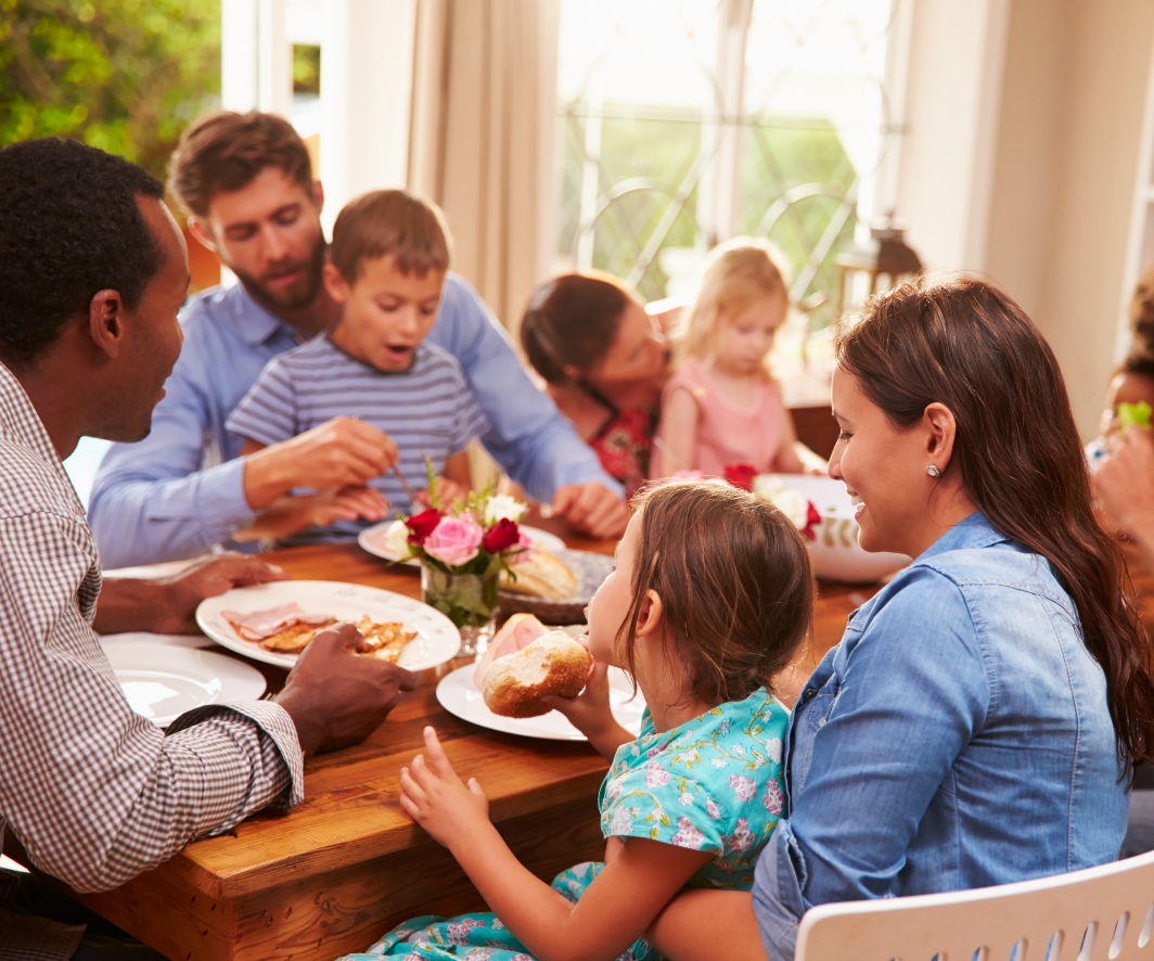 A family is sitting at a table eating food.