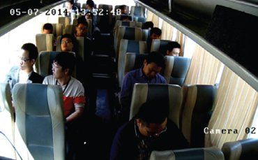 A group of people sitting on a bus with the date 05-07 2013