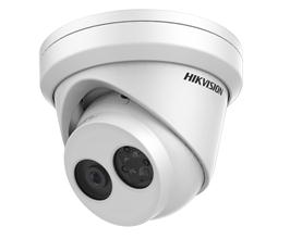 A white hikvision camera is sitting on a white surface.