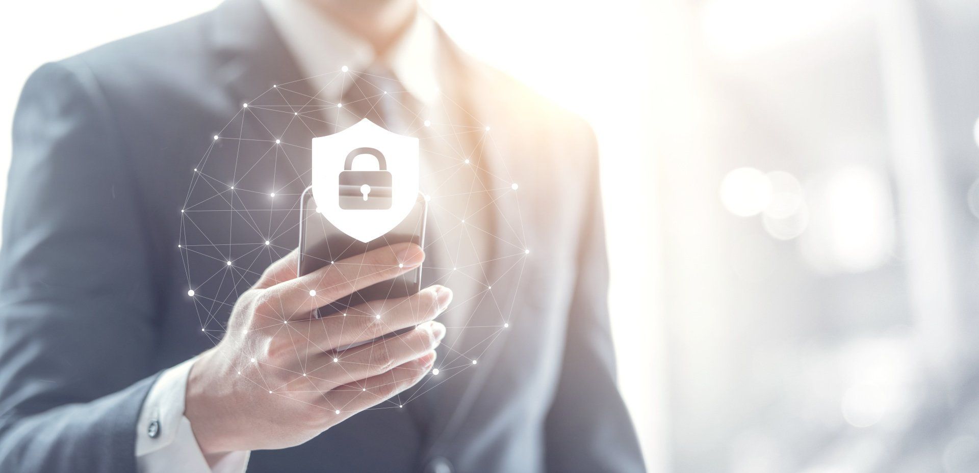 A man in a suit is holding a cell phone with a padlock on it.