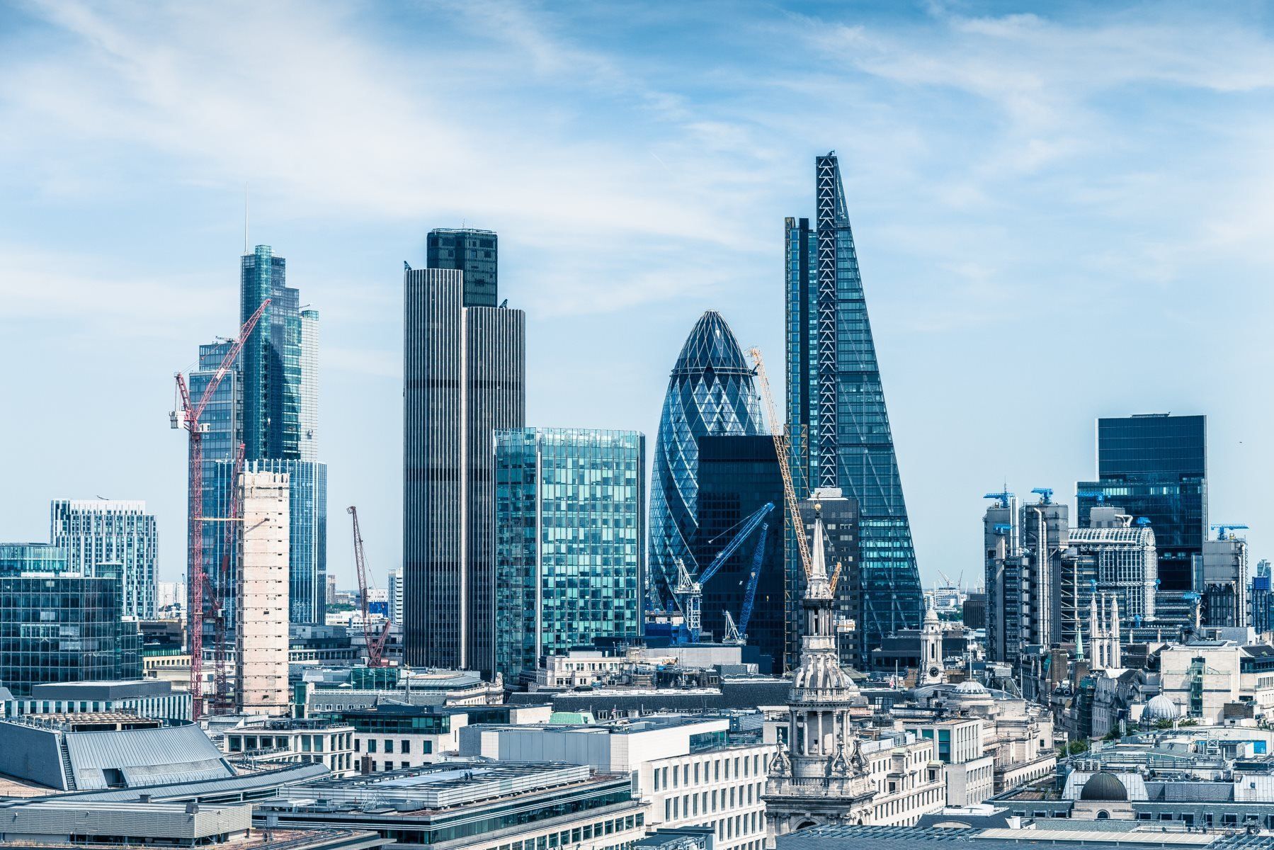 A city skyline with a lot of tall buildings and a blue sky.