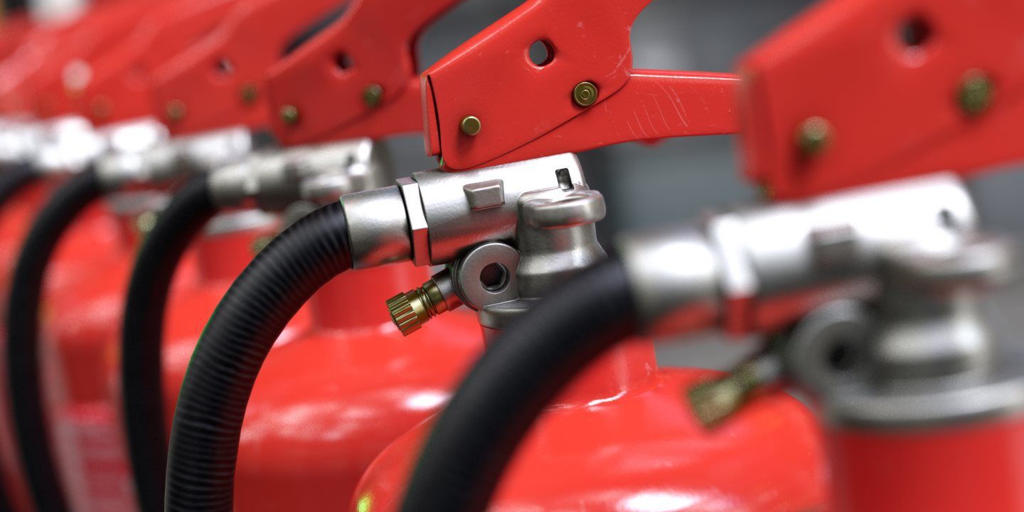 A row of fire extinguishers are lined up in a row.