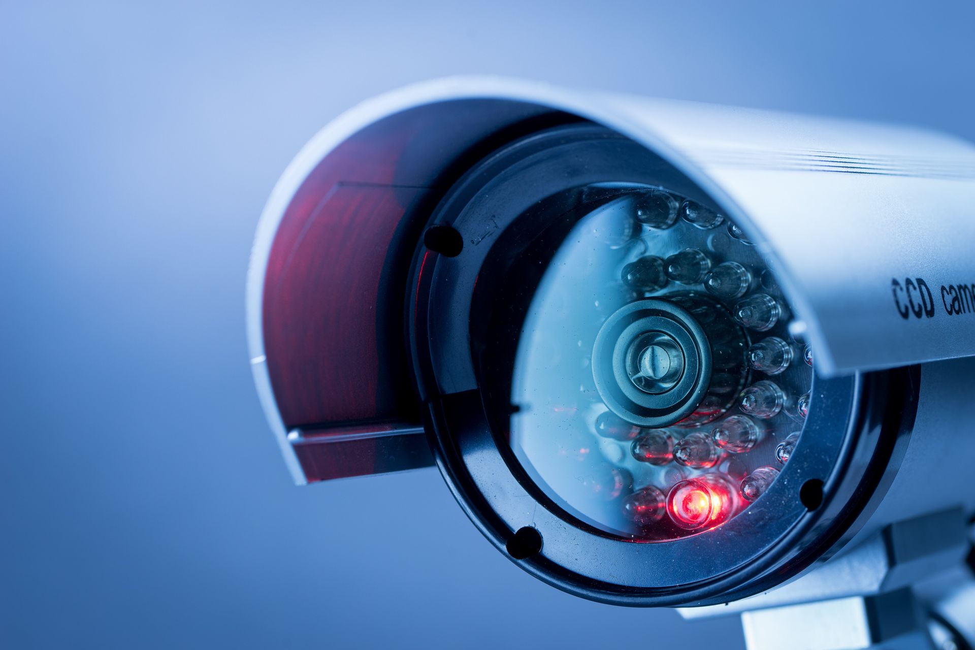 A close up of a security camera with a red light on it.