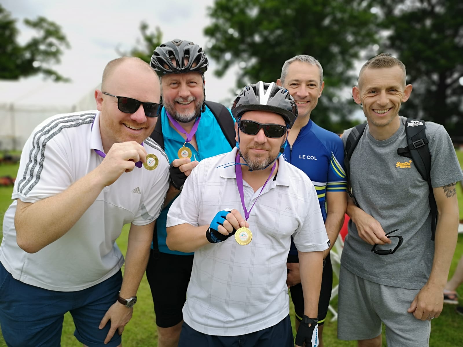 A group of men are posing for a picture and one of them is wearing a medal.