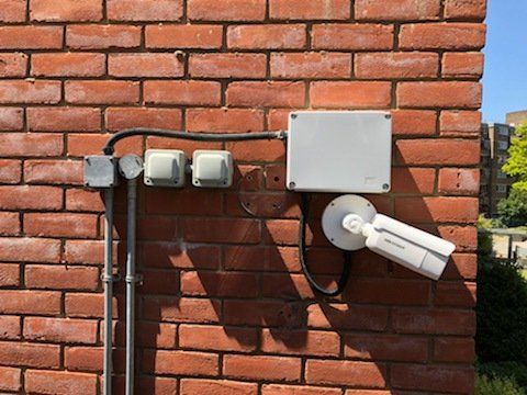 A brick wall with a camera mounted on it