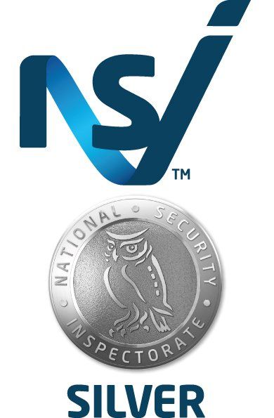 A silver national security inspectorate badge with an owl on it