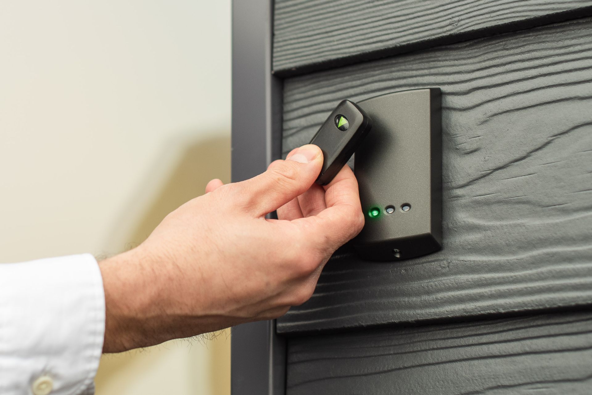 A person is using a remote control to open a door.