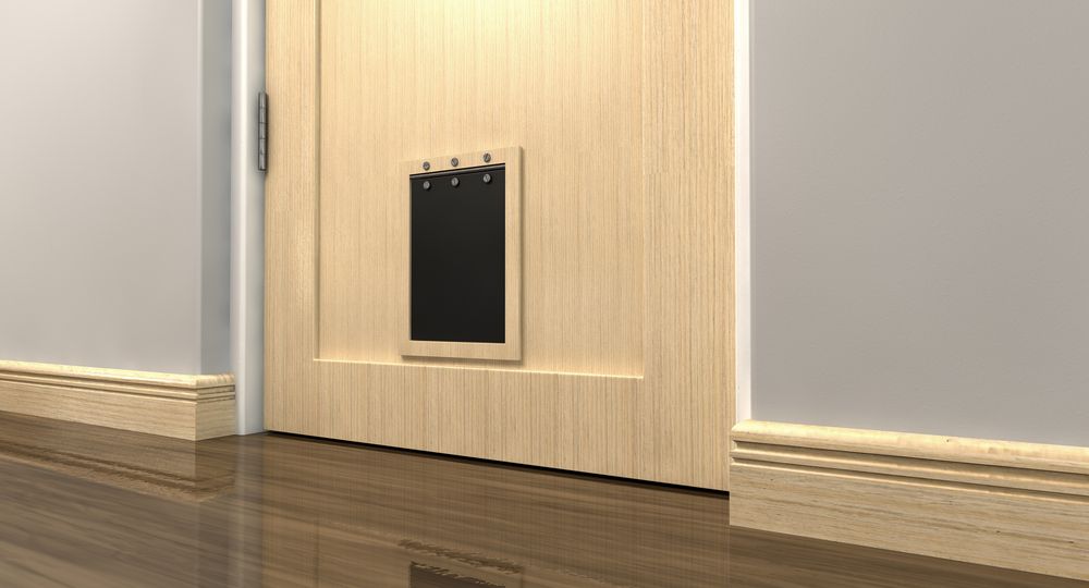 A Inside View of a Regular Black Pet Flap on a Light Wood — Coastal Screens & Glass in Port Macquarie, NSW