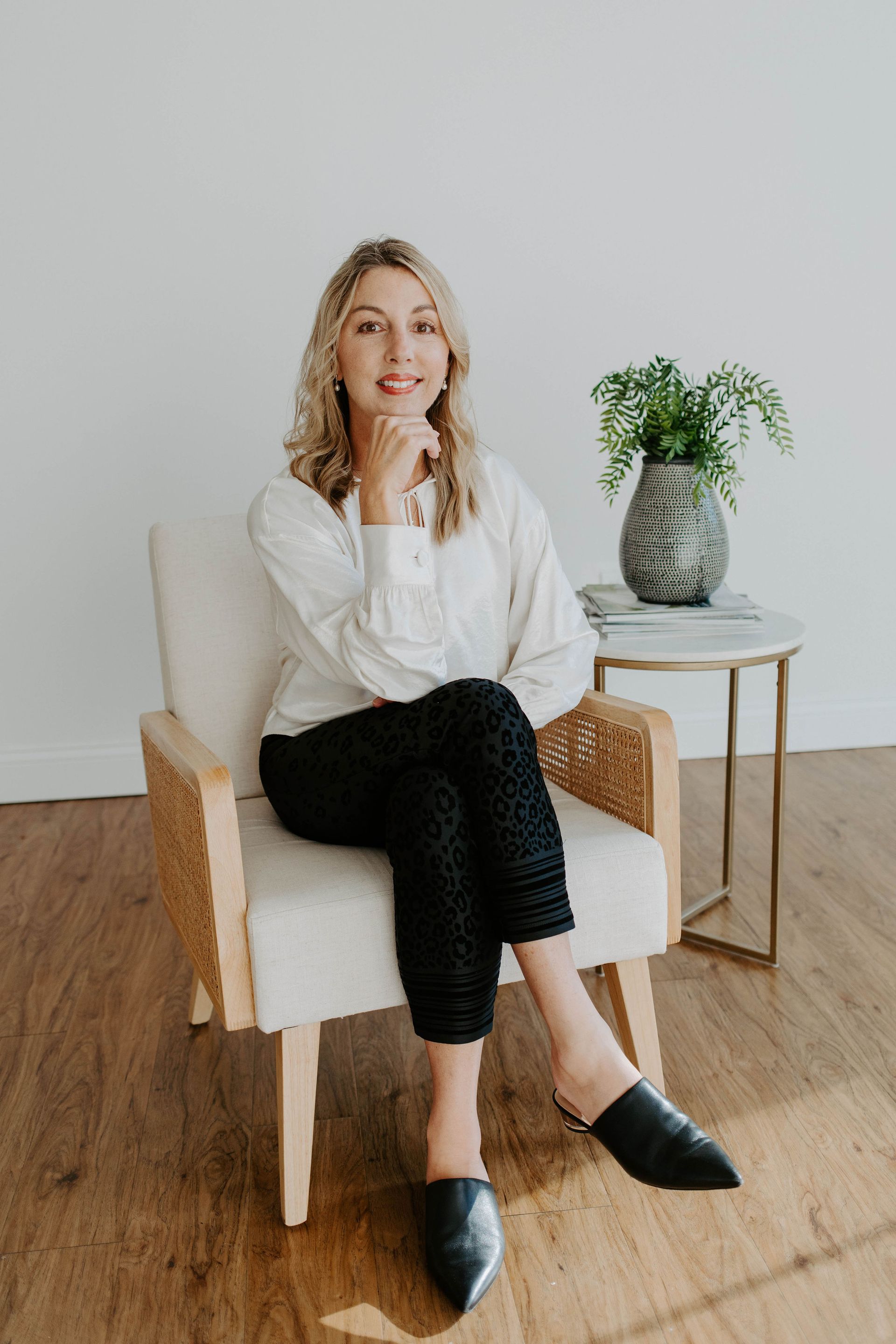 A woman is sitting in a chair with her legs crossed.