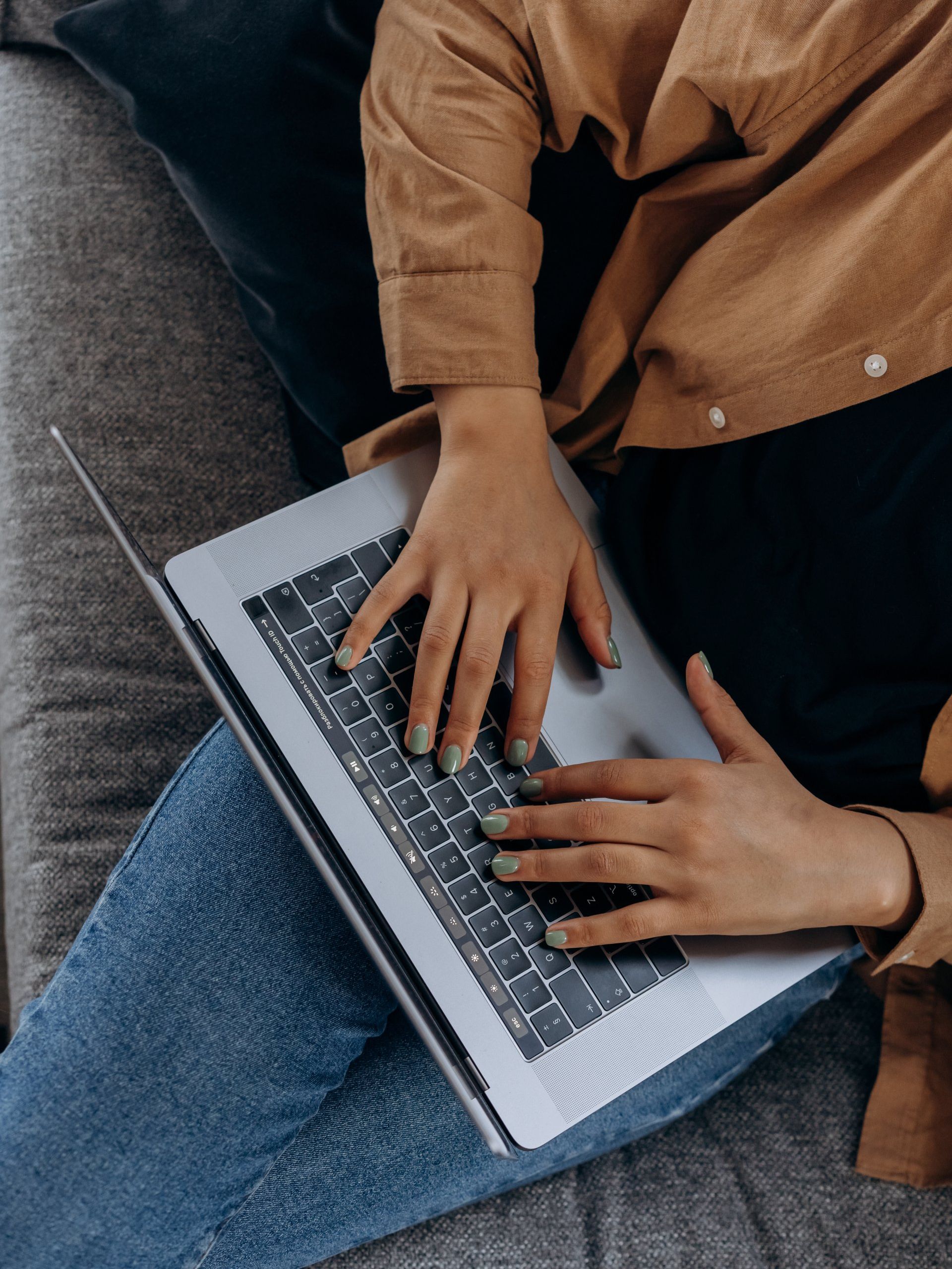 woman holding a laptop in her lap typing