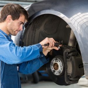 A man is working on a car in a garage.