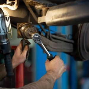 A man is working on a car with a wrench