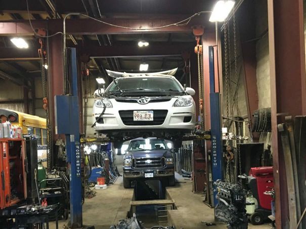 A car is sitting on a lift in a garage.