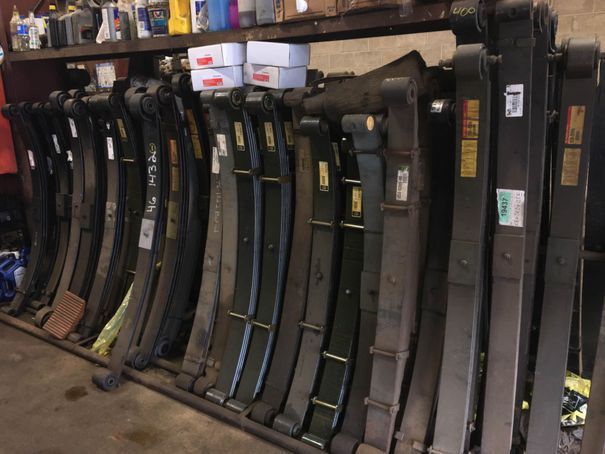A bunch of leaf springs are lined up on a rack