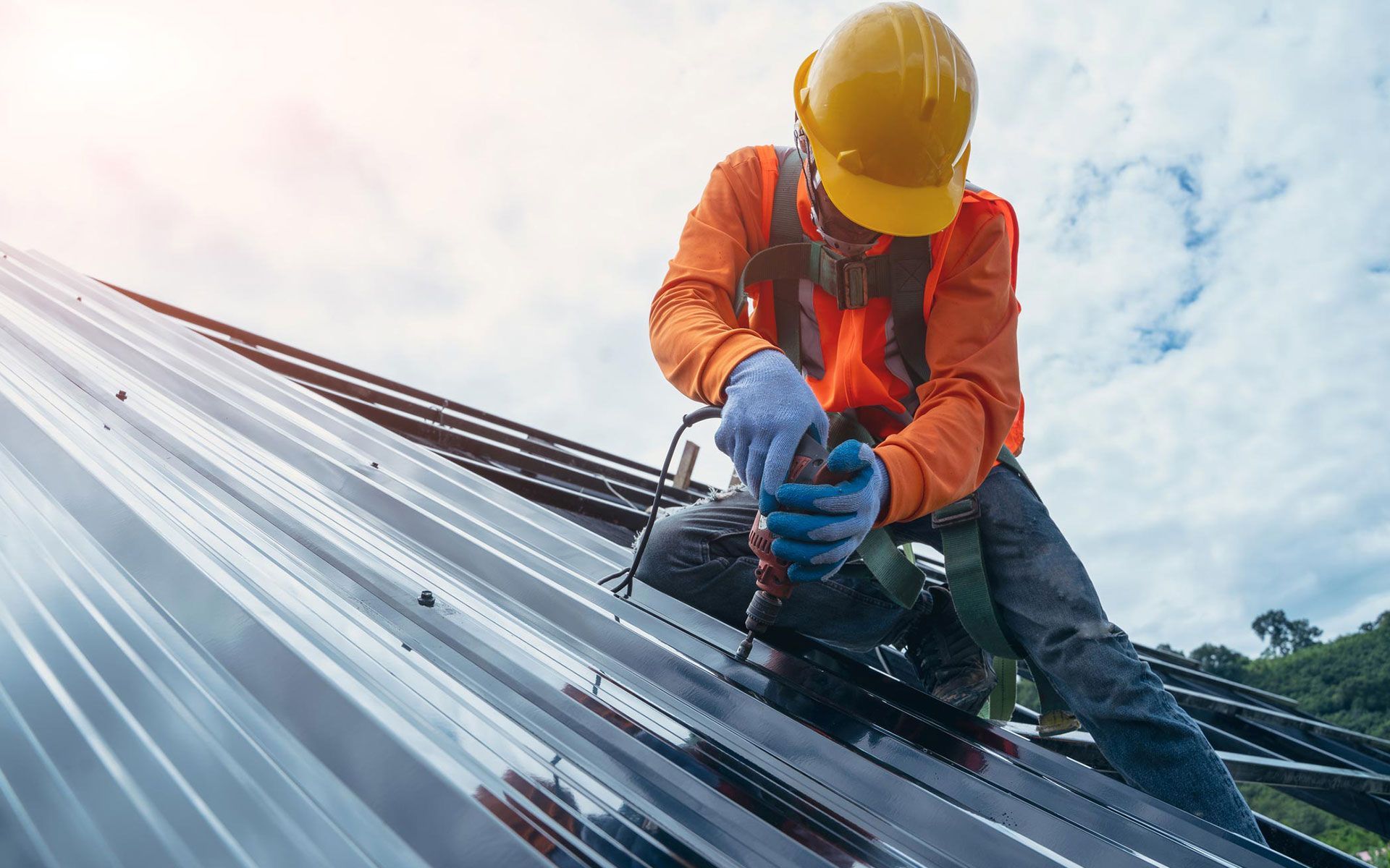 A construction worker is working on a metal roof.