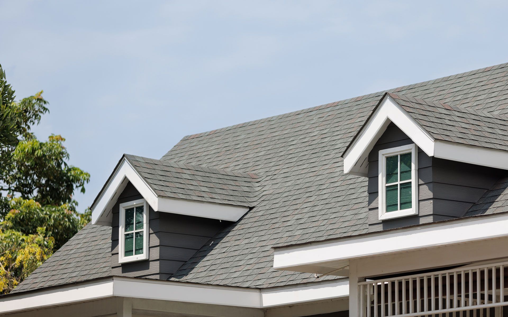 The roof of a house with two windows on it.