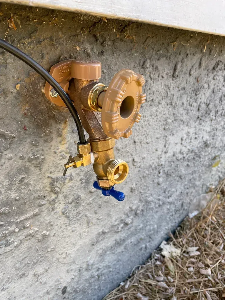 A close up of a faucet attached to a concrete wall.