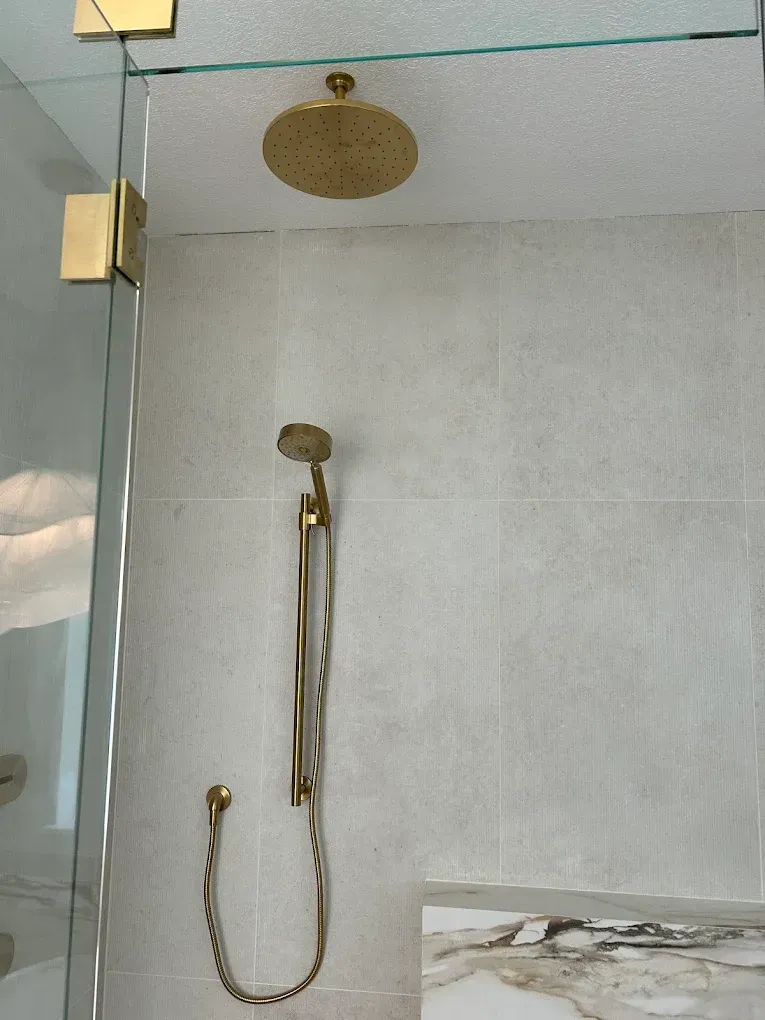 A shower head is hanging from the ceiling in a bathroom